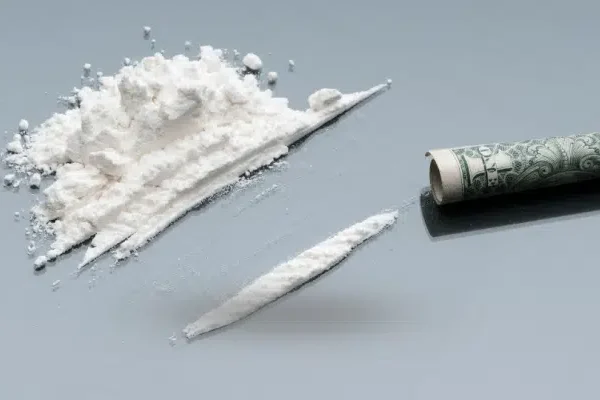 High-purity powder cocaine in a sealed clear bag on a black background