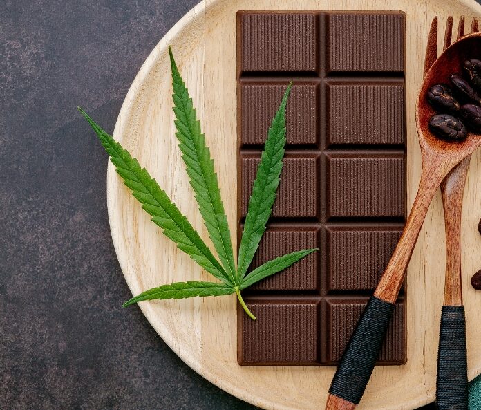 CBD chocolate bar on a nightstand with tea and sleep accessories.
